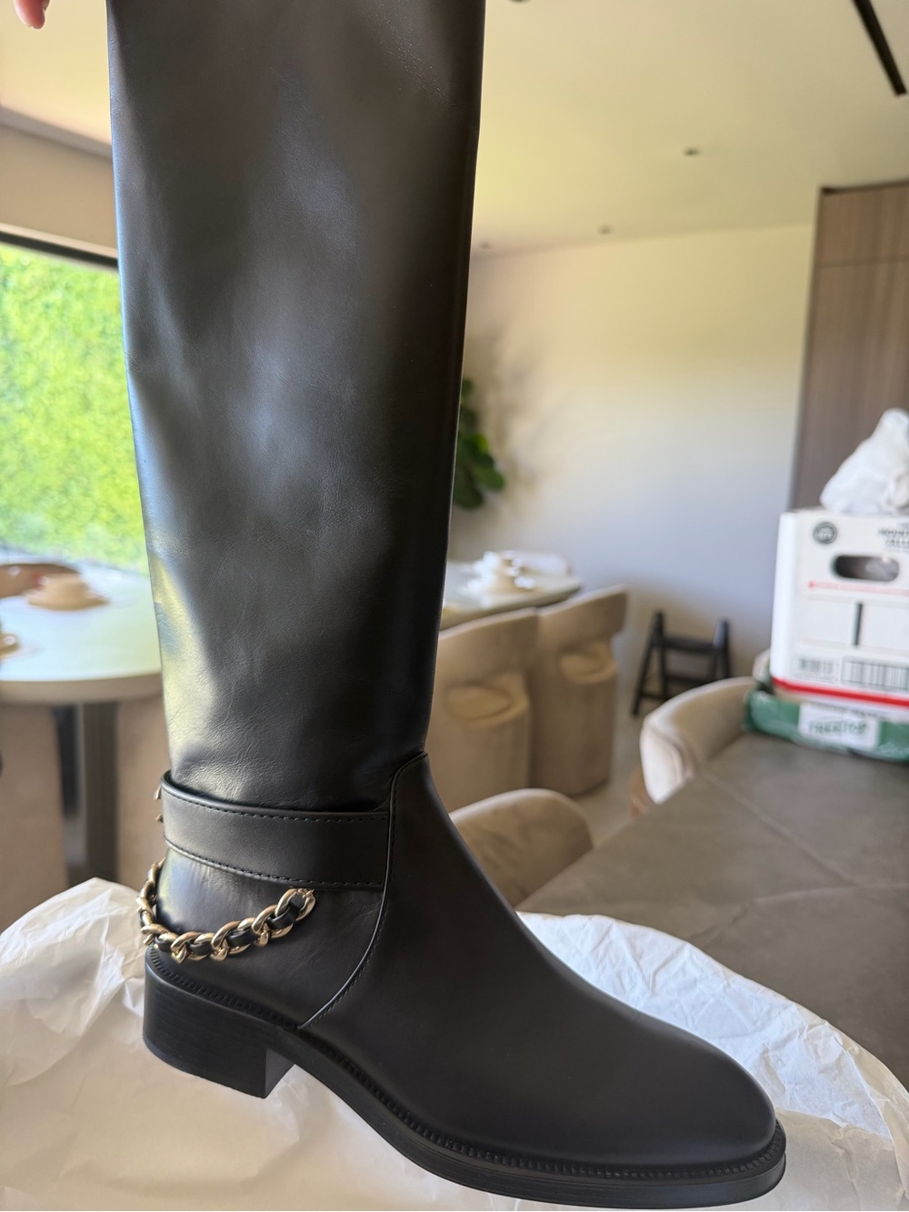 Chanel 
Sleek Black Over-the-Knee Boot with Gold Chain Accent